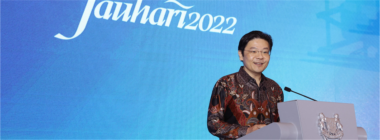 Man at podium with 'Jauhari2022' backdrop. Singapore coat of arms visible.